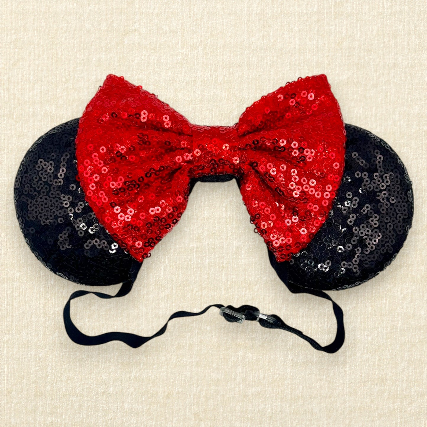 Black sequin mouse ears with red sequin bow on an elastic headband