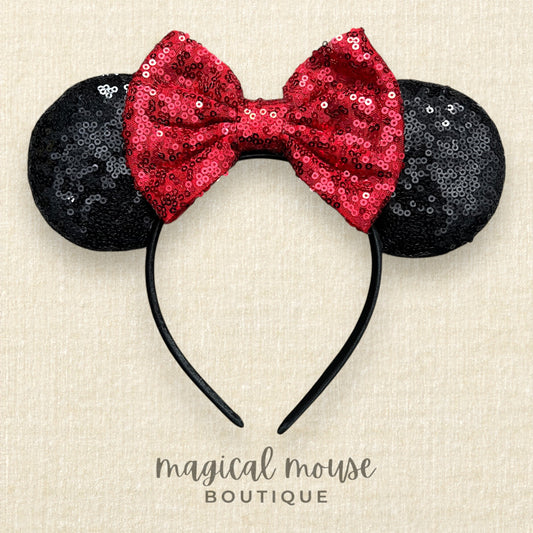 Mouse ears with a red sequin bow on a beige background, branded 'magical mouse boutique'.
