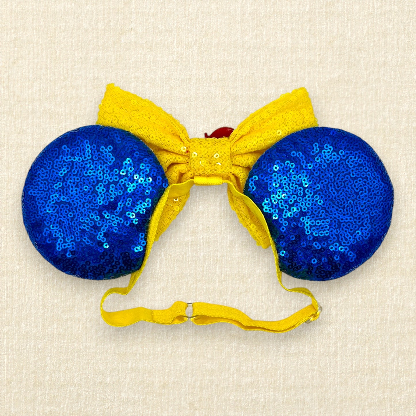 Blue sequin mouse ears with yellow bow, red glitter details, glitter bluebirds, and a red glitter apple centerpiece