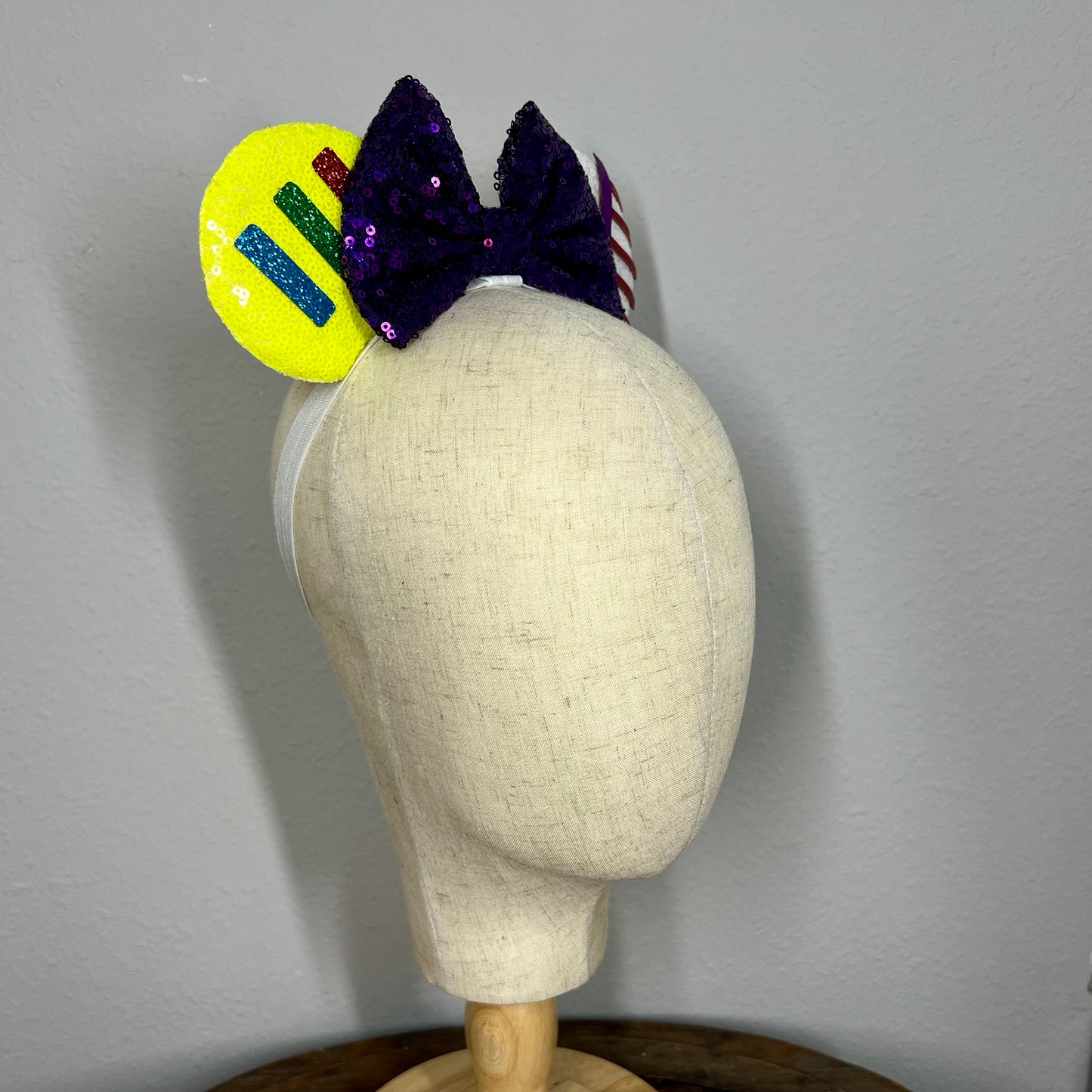 Colorful elastic mouse ears headband with bow on a mannequin head