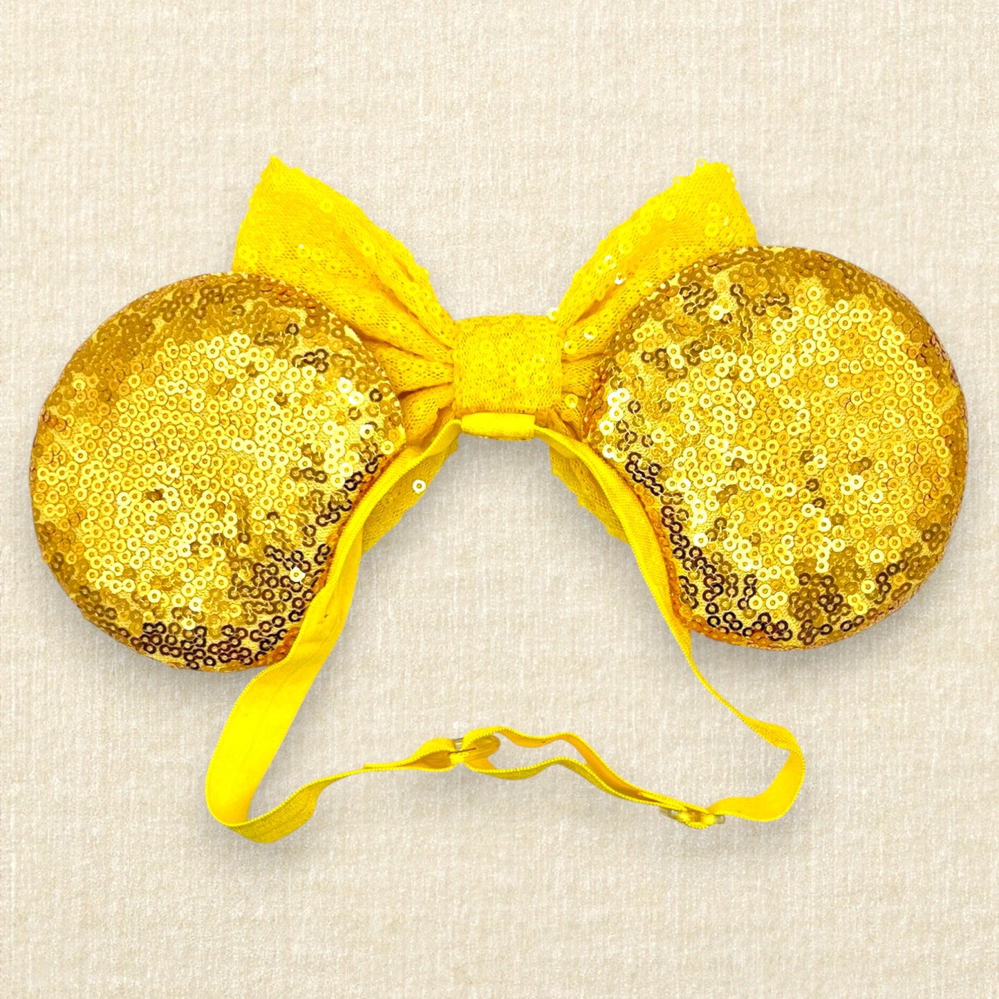 Gold sequin mouse ears with a yellow bow, silver tiara, and red roses on an elastic headband (back view)