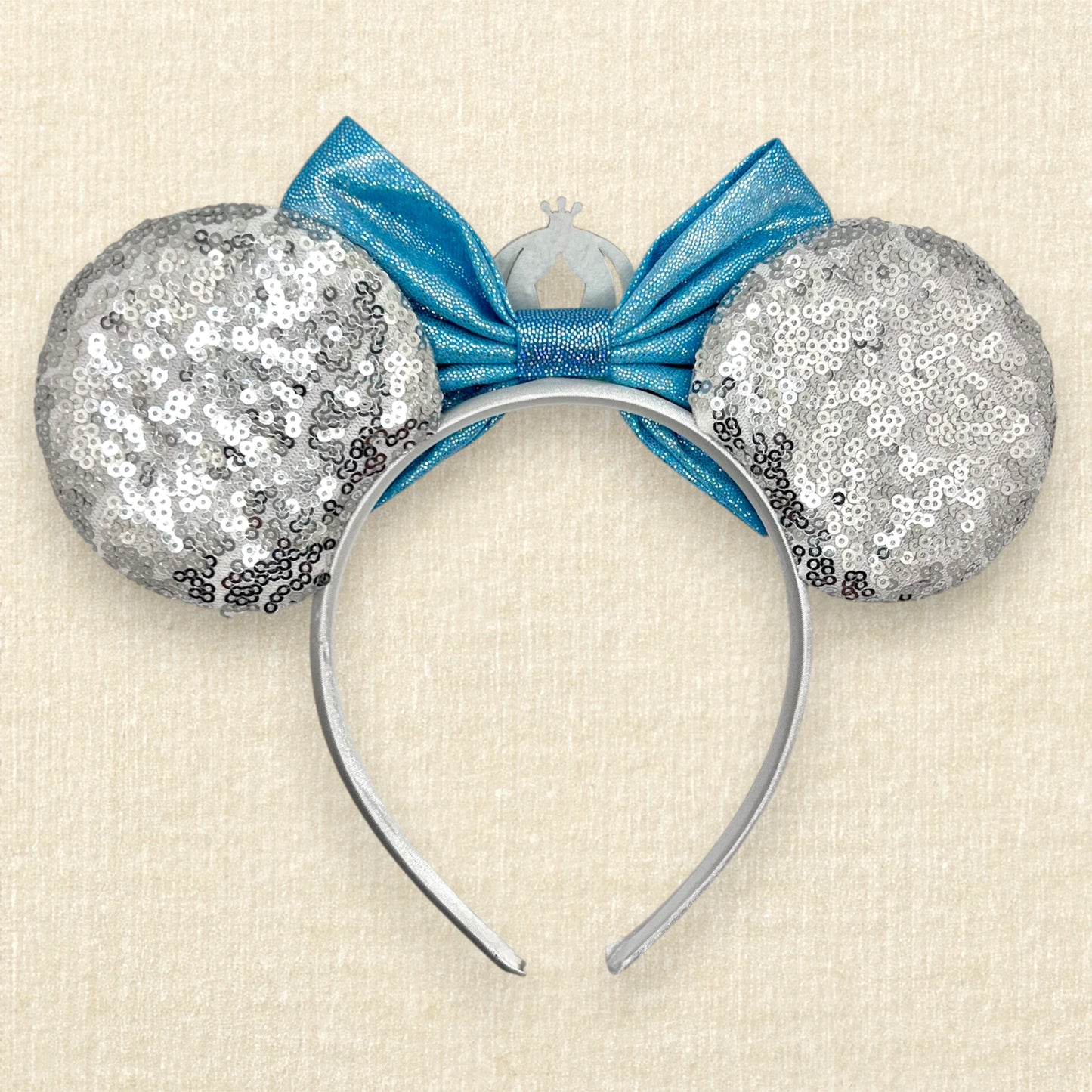 Silver sequin mouse ears with shimmery blue bow, silver glitter carriage accent, and rhinestones (back view)