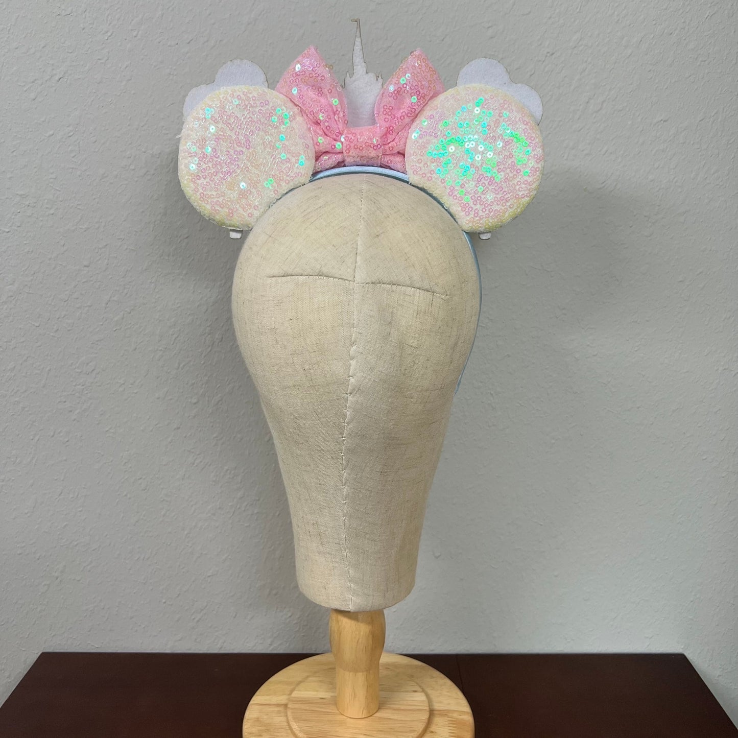 Colorful headband with castle and balloons design on a mannequin head against a gray background