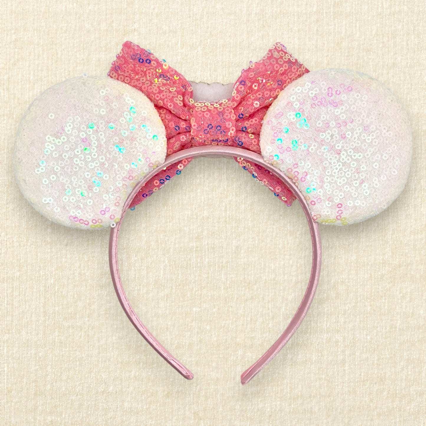 Iridescent white mouse ears with colorful mouse pearls, a pink sequin bow, and glitter "Birthday Girl" text centerpiece (back view)