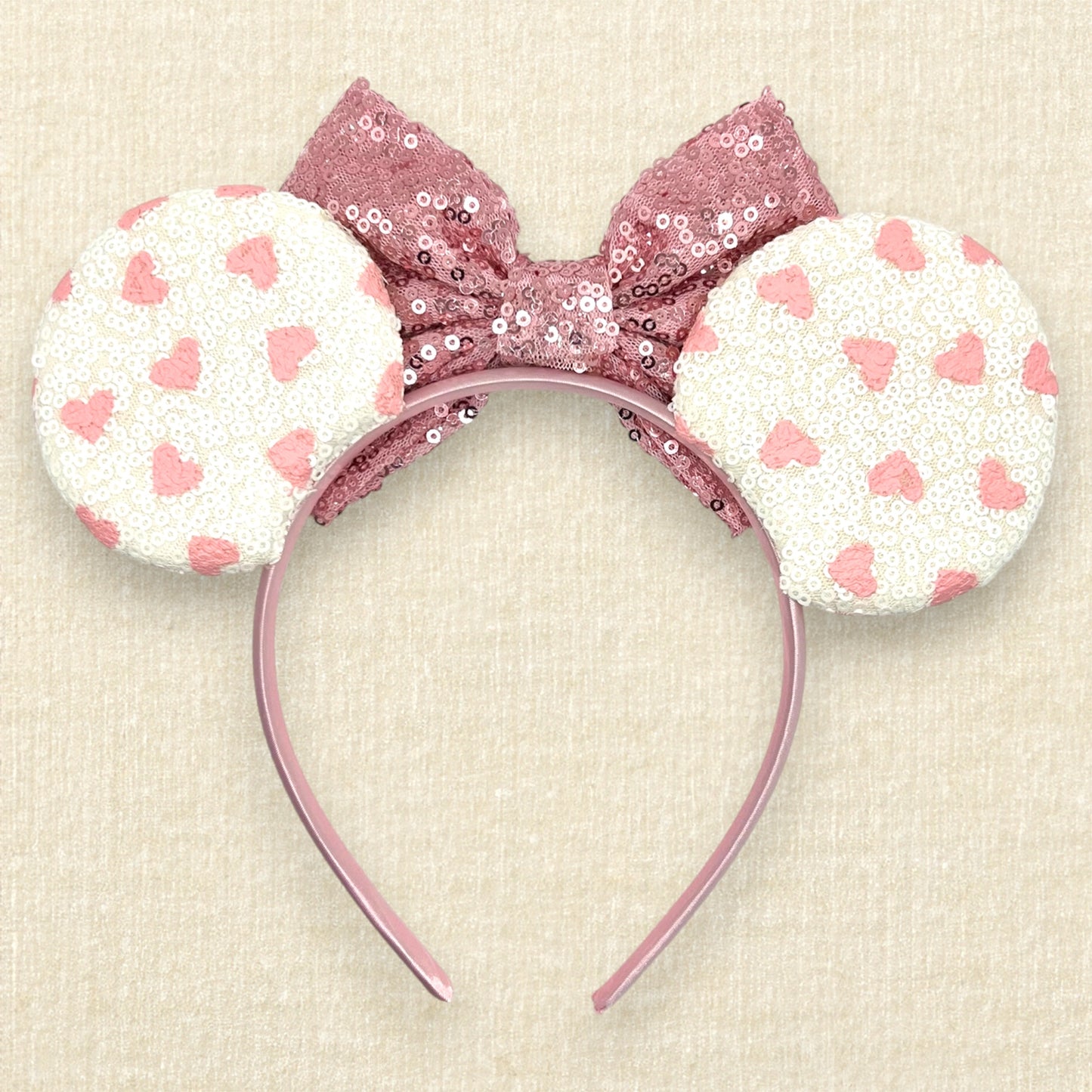 White sequin mouse ears with small pink hearts and rose gold sequin bow (back view)