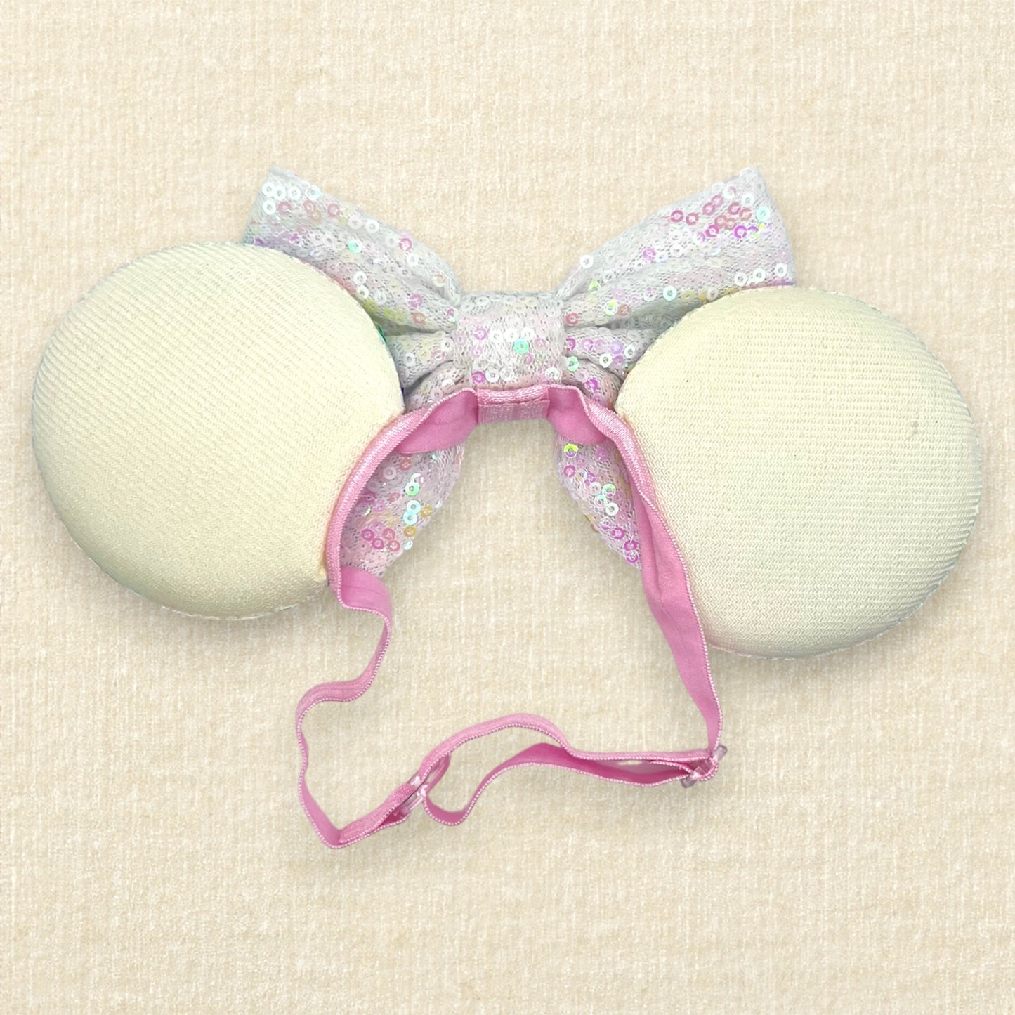 Colorful sequin mouse ears with white sequin bow on an elastic headband (back view)