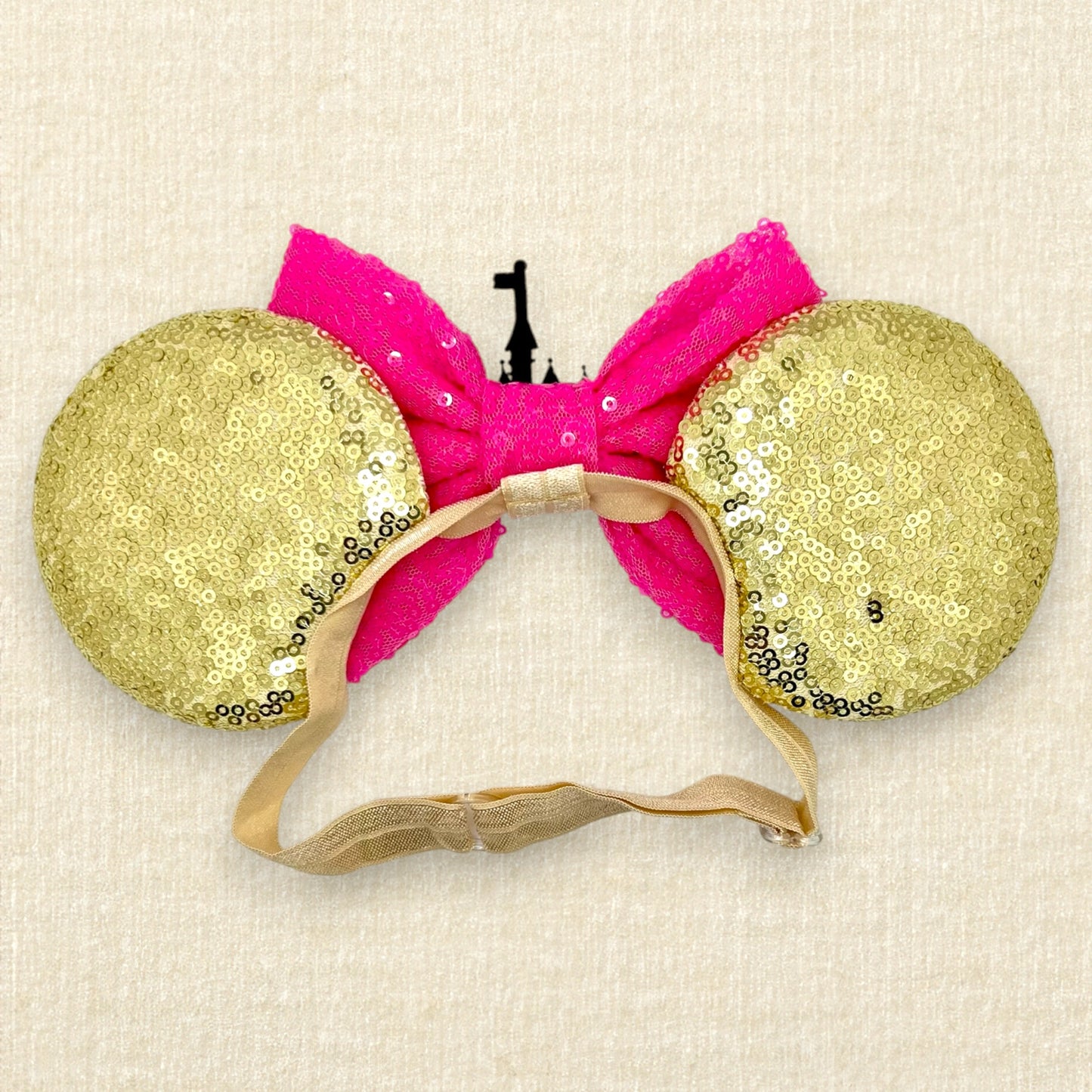 Gold sequin mouse ears with hot pink sequin bow and gold glitter storybook castle on an elastic headband (back view)