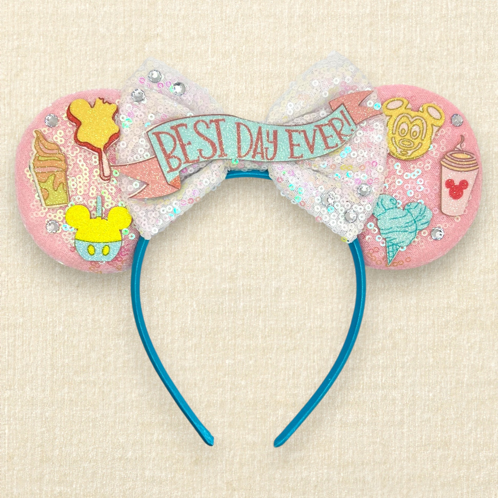 Pink mouse ears headband with glitter theme park snack details, iridescent white bow, and glitter "Best Day Ever!" text