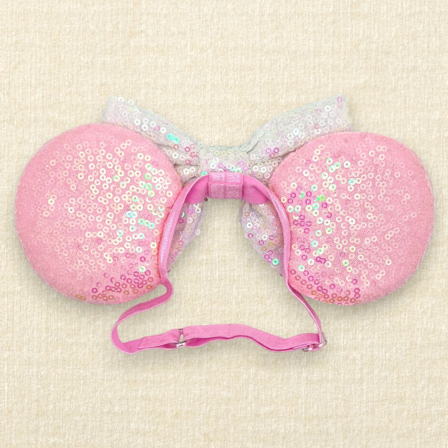 Pink mouse ears with glitter theme park treats, iridescent white bow, and glitter "Best Day Ever!" text on an elastic headband (back view)