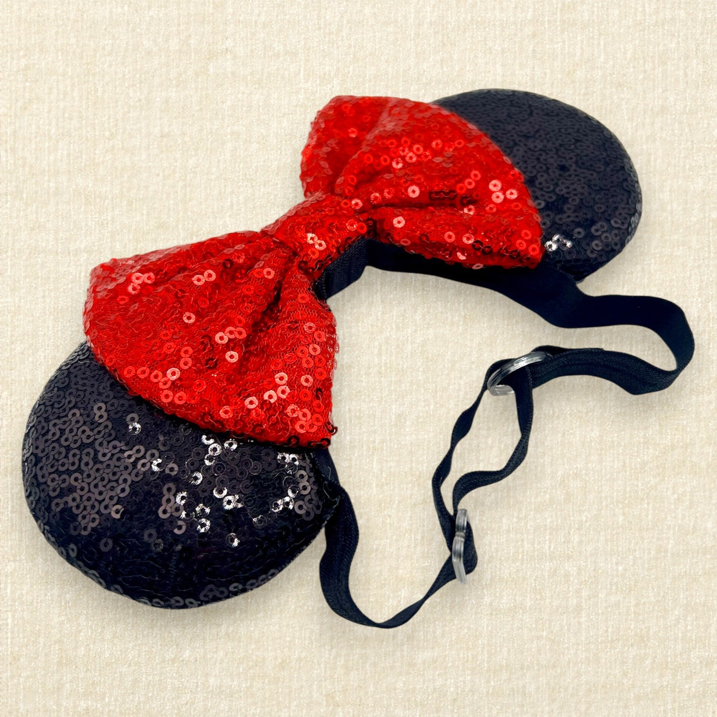 Black sequin mouse ears with red sequin bow on an elastic headband