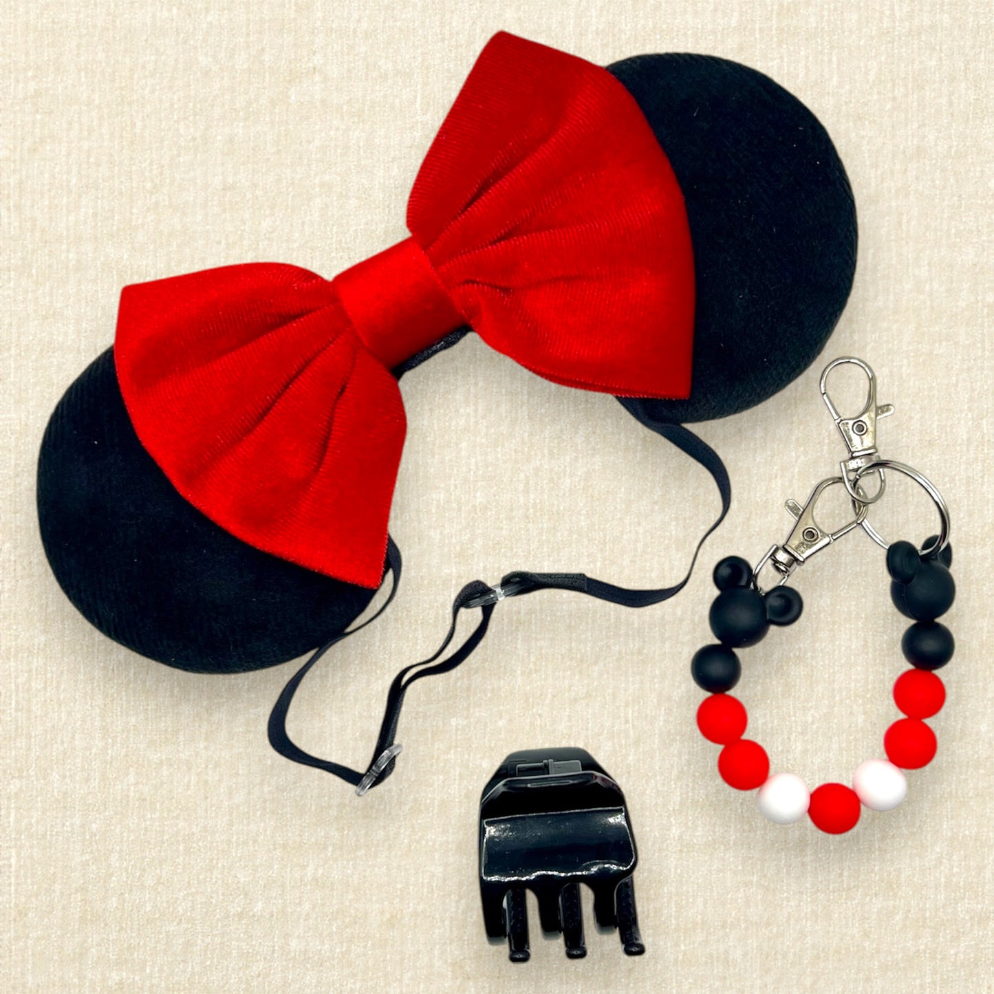 Black velvet mouse ears with red velvet bow on an elastic headband; black claw clip; black and red beaded mouse ears holder clip