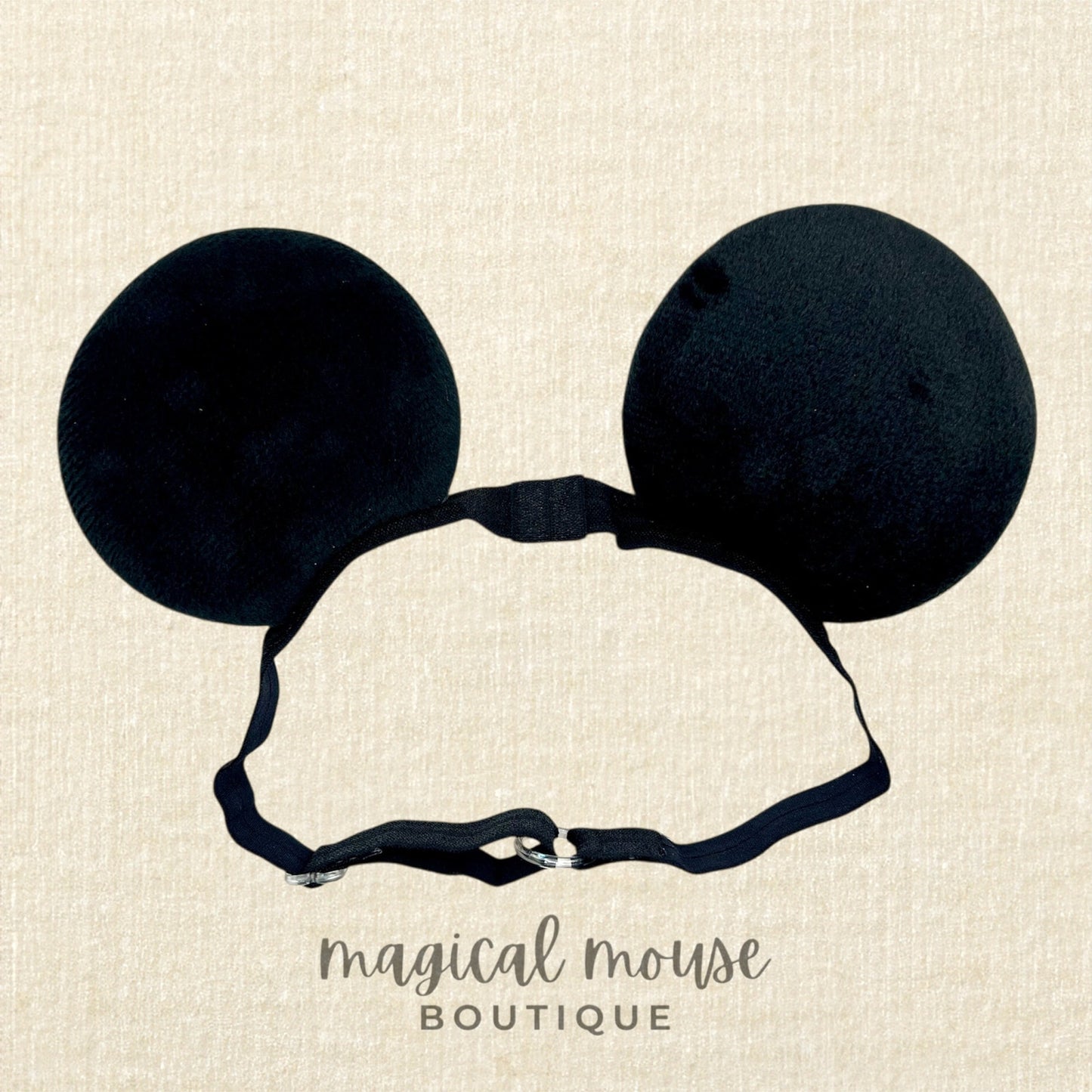 Black mouse ears headband on a beige background with 'magical mouse boutique' text.