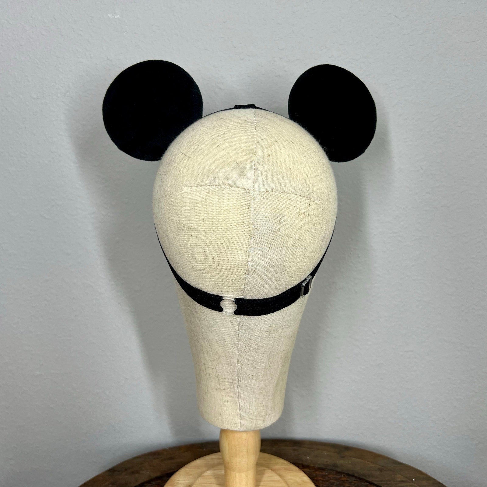 Mannequin head with black mouse ears on a plain background