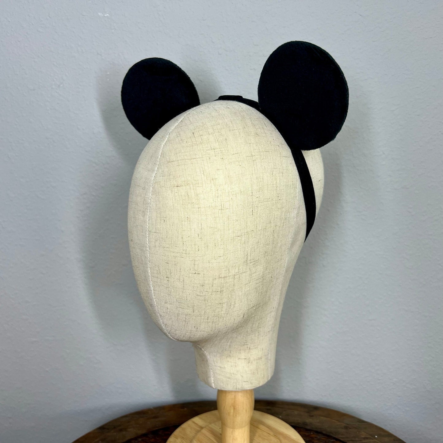 Mannequin head with black mouse ears on a plain background