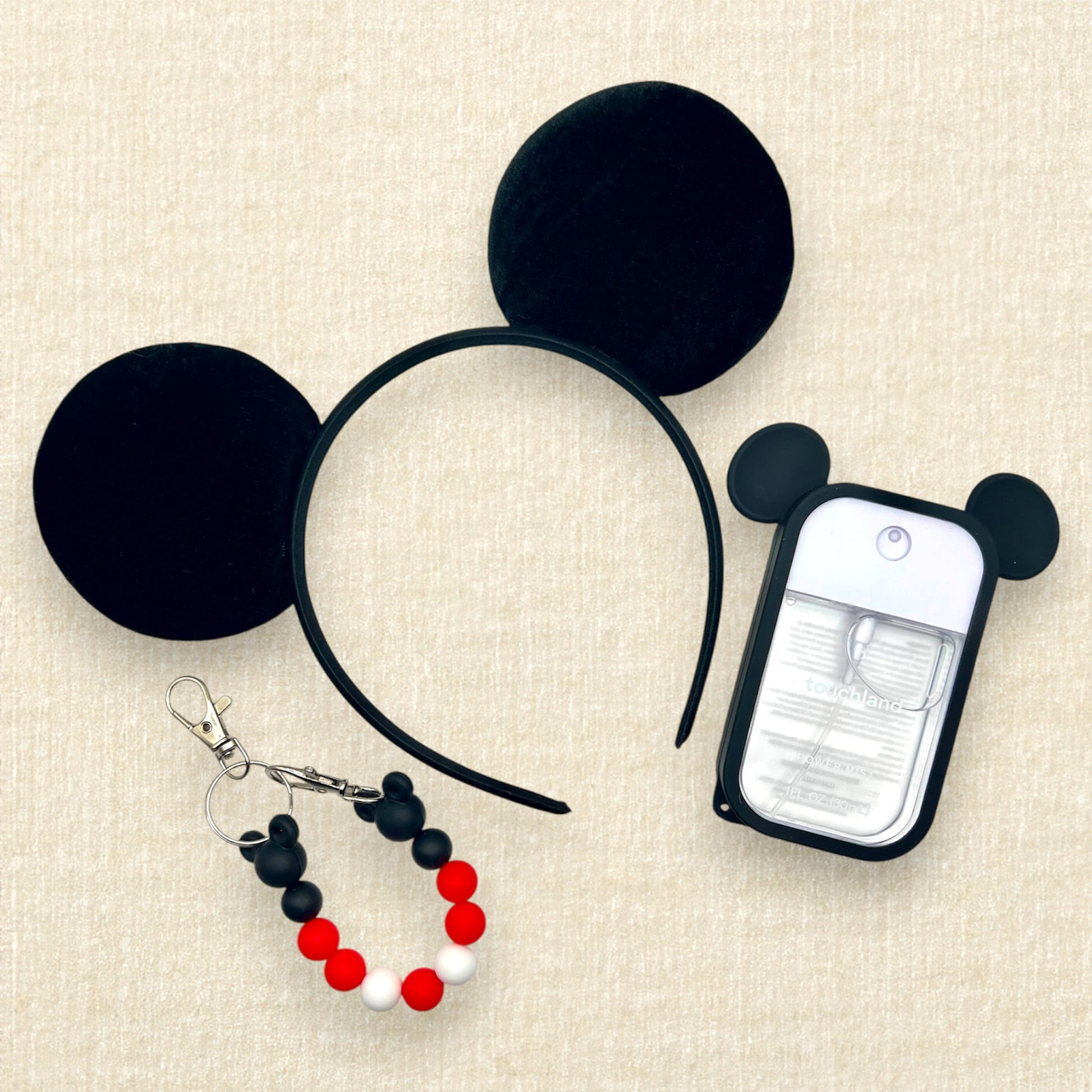 Black velvet bow-free mouse ears headband, black and red beaded mouse ears holder clip, and spray hand sanitizer in a mouse ears case