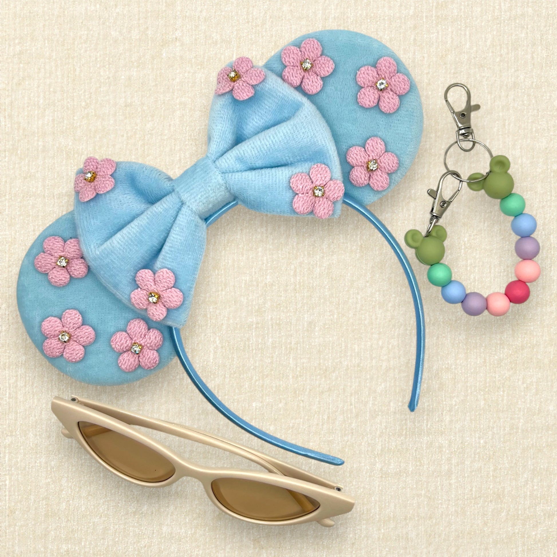 Blue velvet mouse ears and bow with pink fabric flowers; cream cat-eye sunglasses; colorful beaded mouse ears holder clip