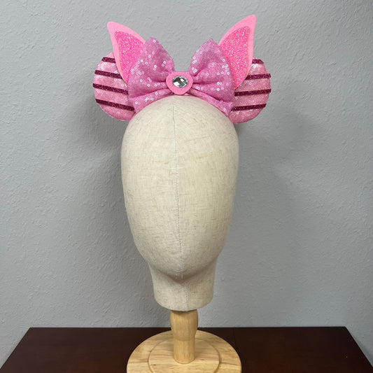 Pink sequin mouse ears with bow on a mannequin head