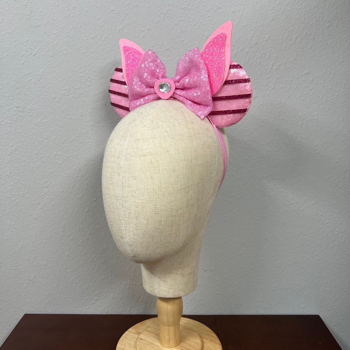 Pink sequin mouse ears with bow on a mannequin head