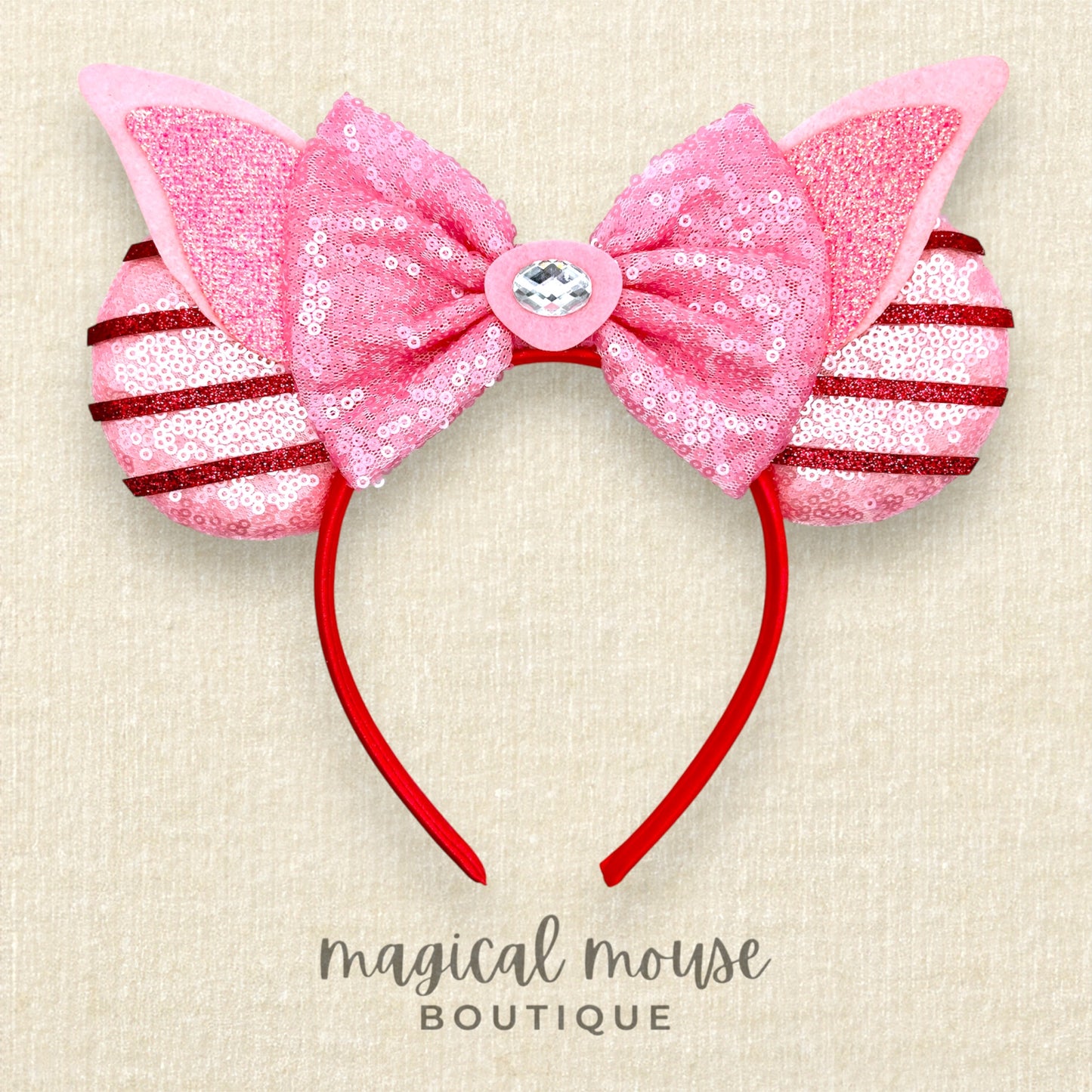 Pink mouse ears headband with sequins on a beige background, labeled 'magical mouse boutique'.
