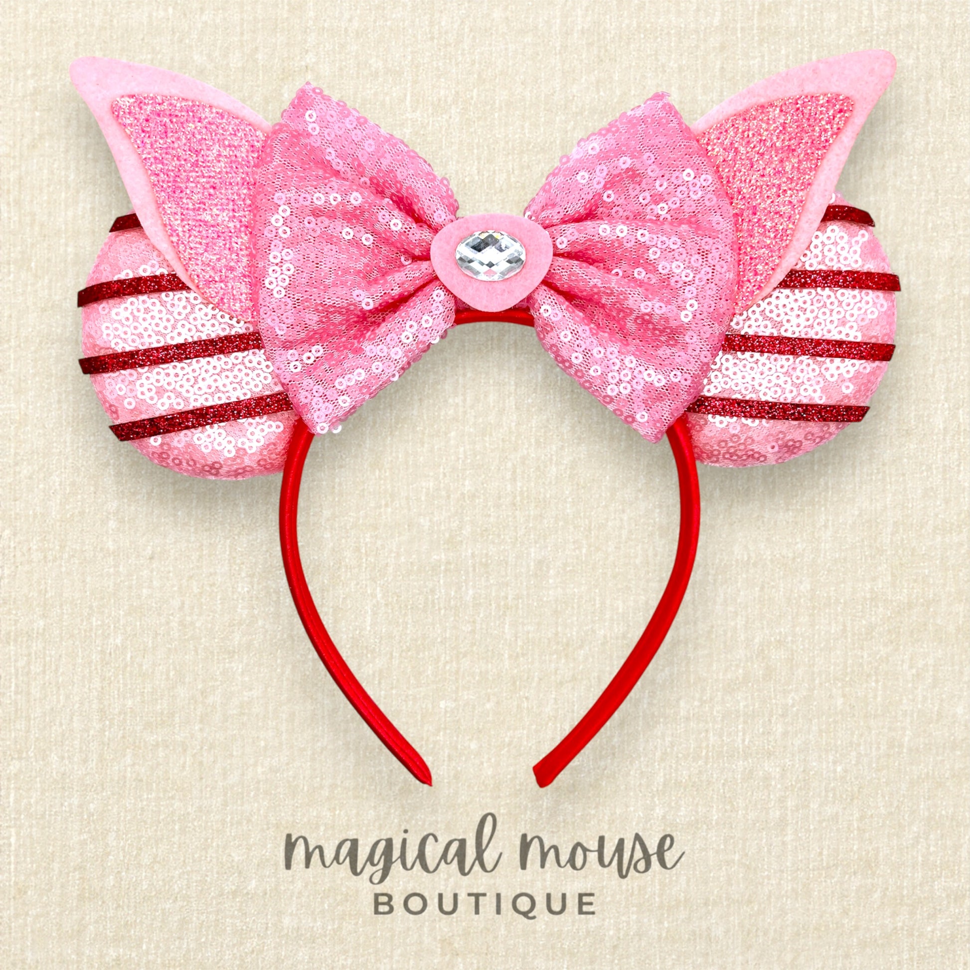 Pink mouse ears headband with sequins on a beige background, labeled 'magical mouse boutique'.