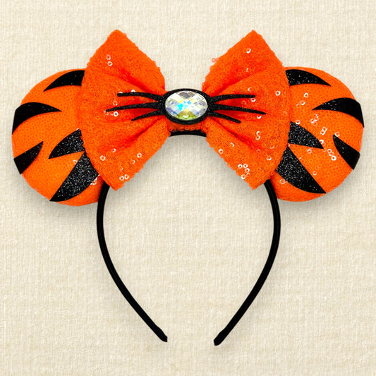 Orange sequin mouse ears headband with matching bow, black glitter tiger stripes, and rhinestone nose with black glitter whiskers