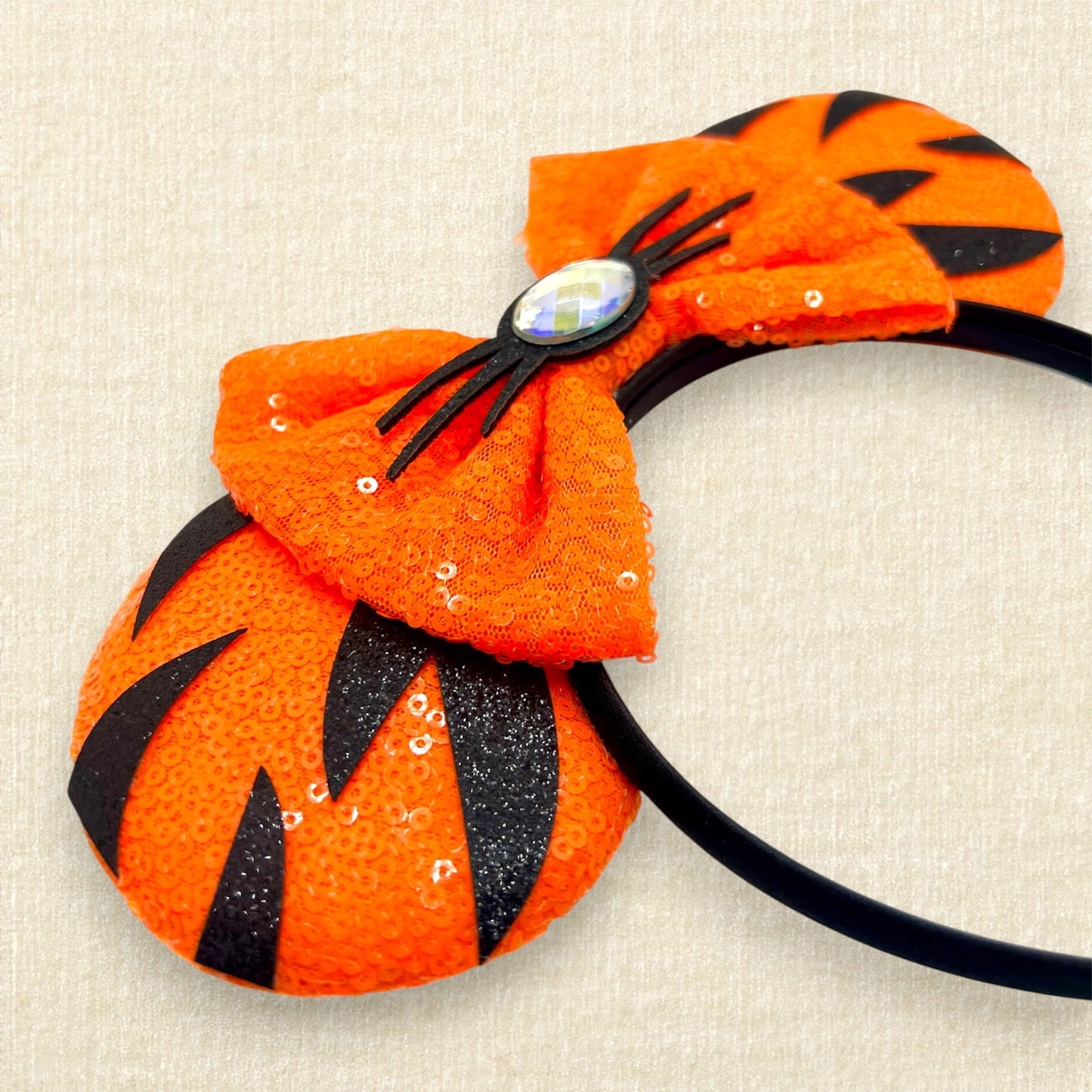 Orange sequin mouse ears headband with matching bow, black glitter tiger stripes, and rhinestone nose with black glitter whiskers