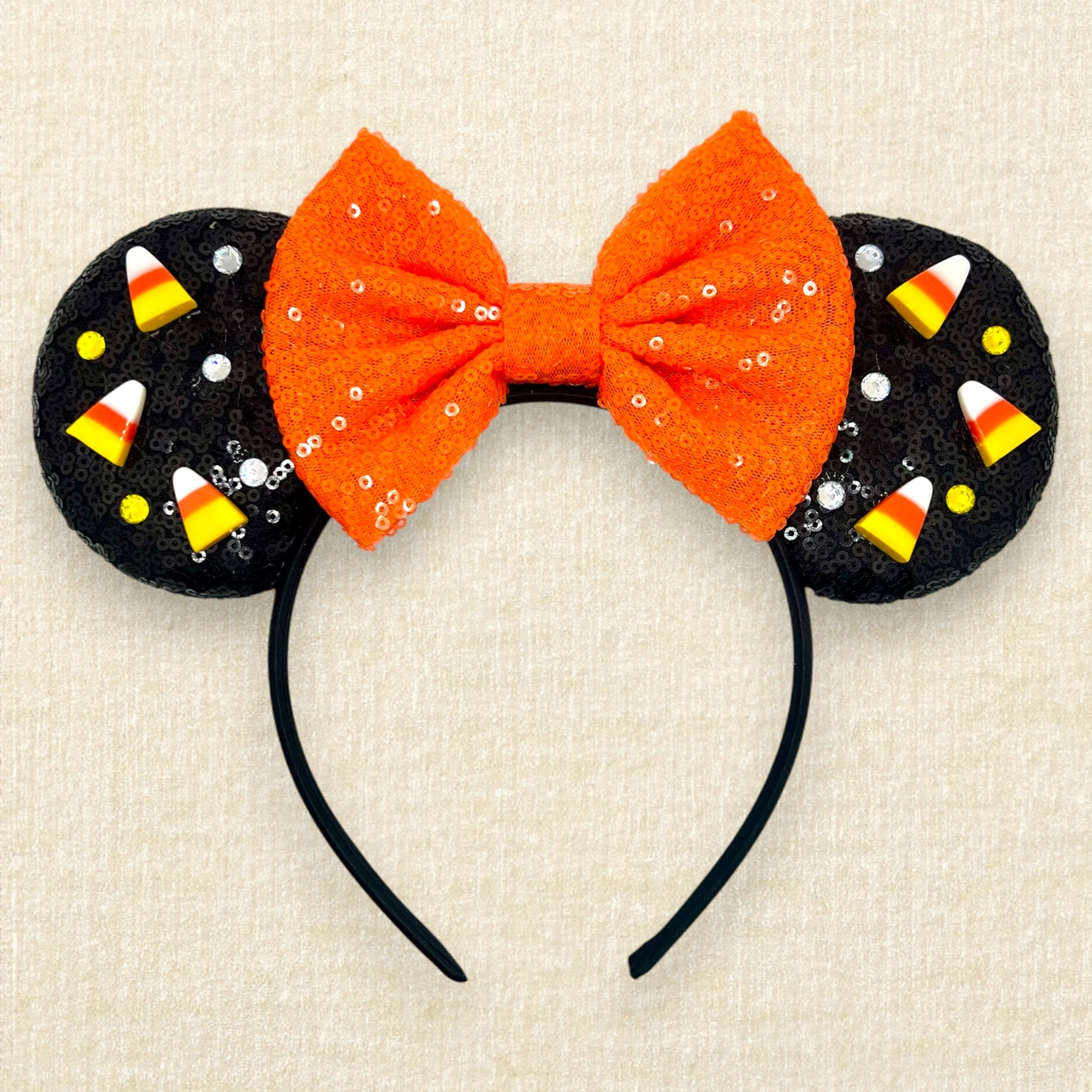 Black sequin mouse ears with candy corn pieces, rhinestones, and orange sequin bow