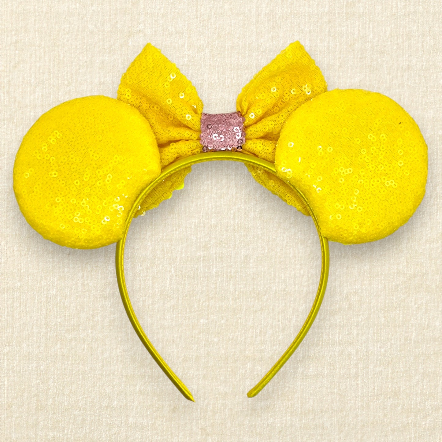 Yellow floral mouse ears headband with yellow daisies and bees and a bow on a beige background (back view)