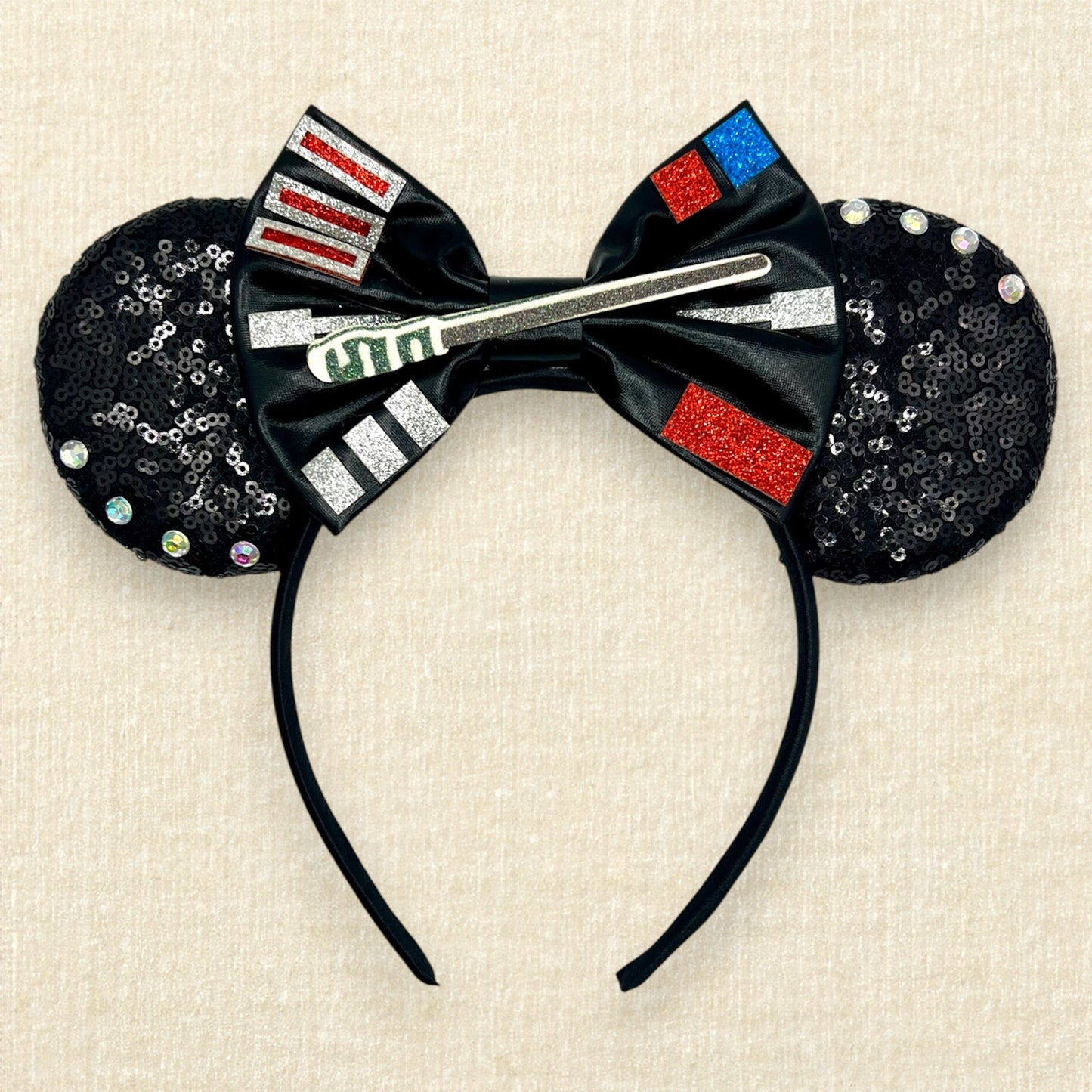 Black sequin mouse ears headband with metallic black bow, glitter details, and rhinestones