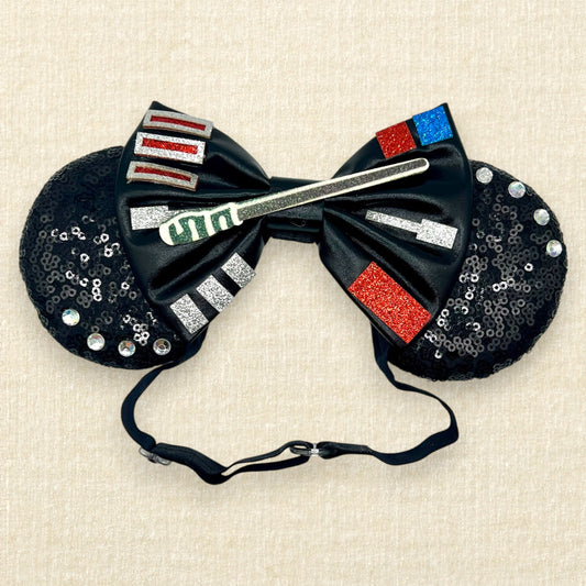 Black sequin mouse ears headband with metallic black bow, colorful glitter details, and rhinestones on an elastic headband