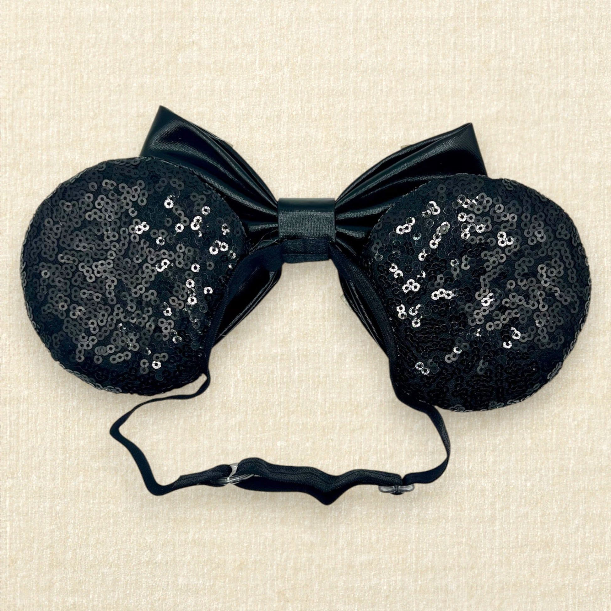 Black sequin mouse ears headband with metallic black bow, colorful glitter details, and rhinestones on an elastic headband (back view)