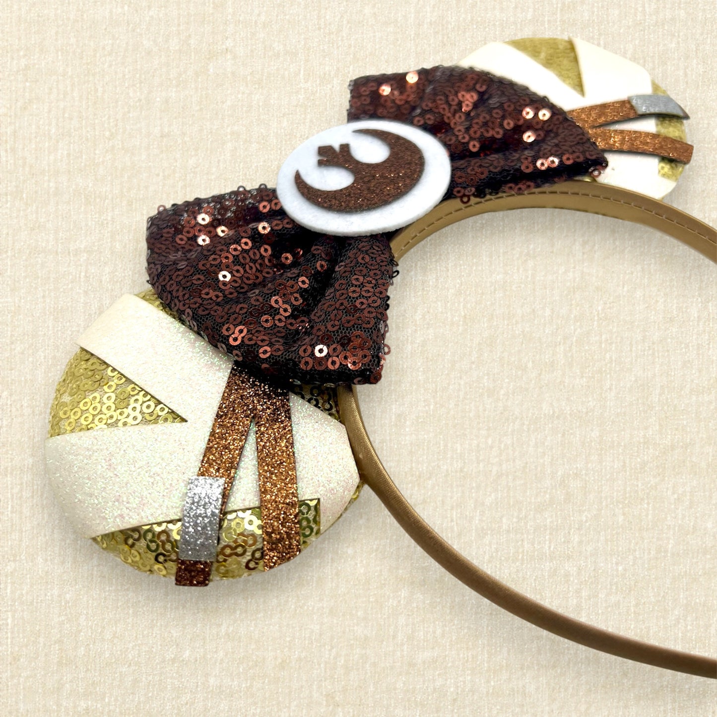 Gold sequin mouse ears with brown and white glitter details, brown sequin bow, and brown glitter emblem