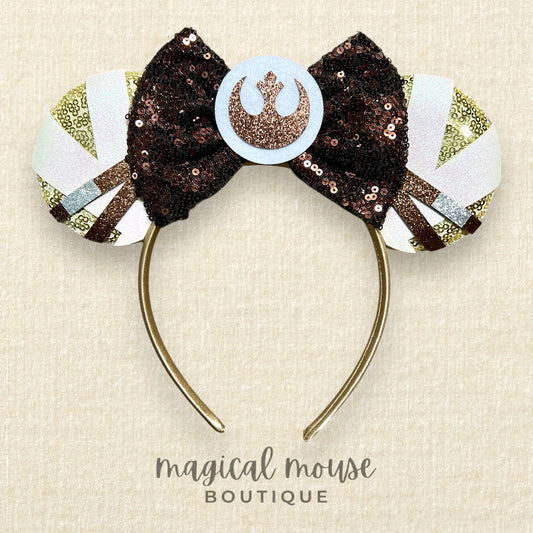Decorative headband with a bow and emblem on a beige background, branded 'Magical Mouse Boutique'.