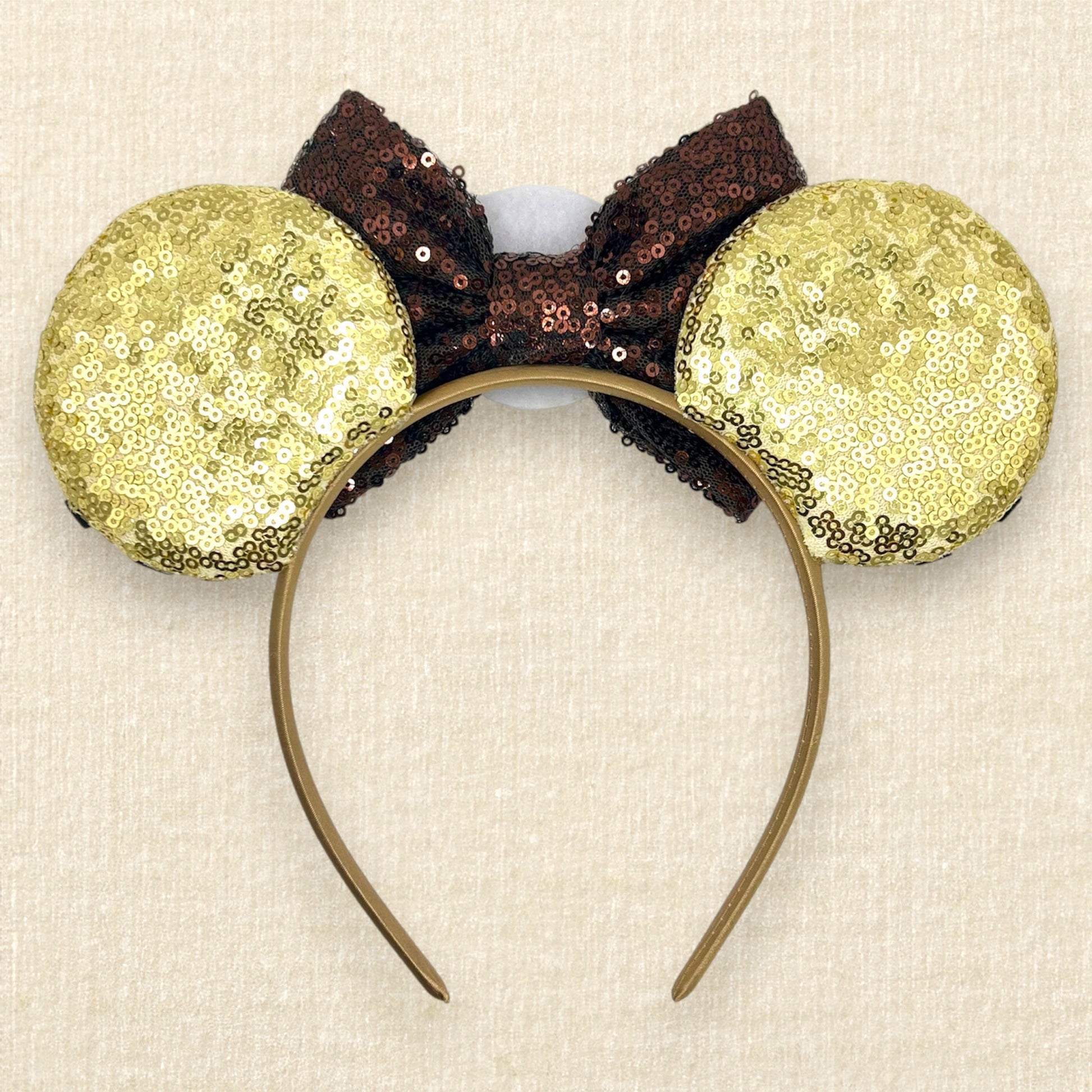 Gold sequin mouse ears with brown and white glitter details, brown sequin bow, and brown glitter emblem (back view)