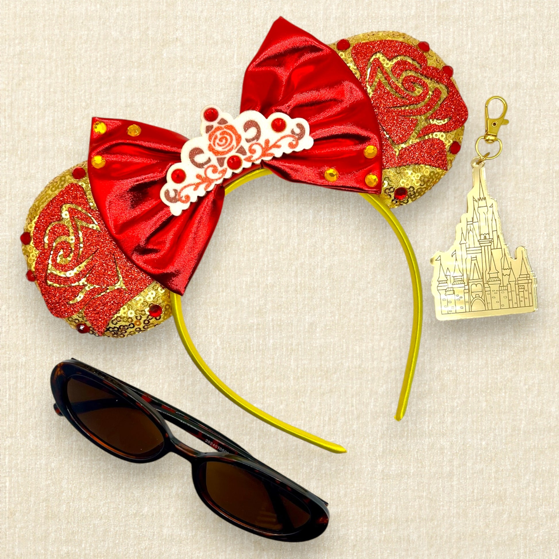 Gold mouse ears with red glitter roses, metallic red bow, glitter rose tiara, and rhinestones; sunglasses; gold castle keychain