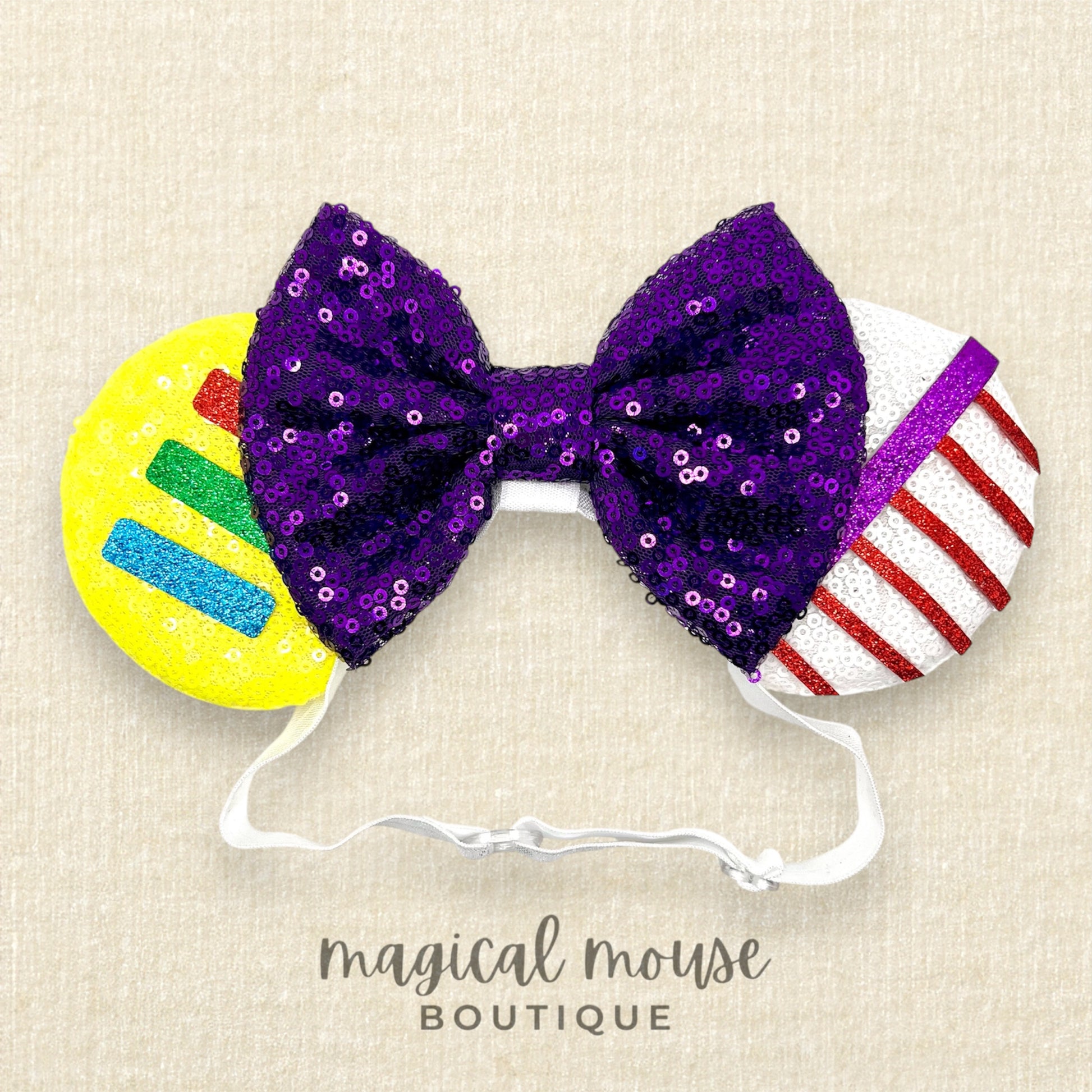 Colorful bow and mouse ears headband with sequins on a beige background, featuring the brand 'magical mouse Boutique'.
