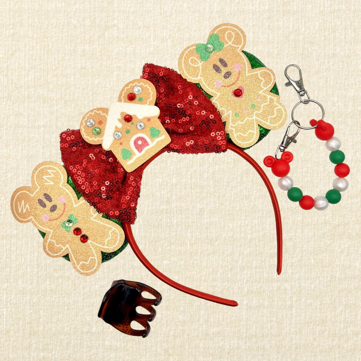 A festive Christmas-themed mouse ears headband featuring gingerbread mouse cookies, a red sequin bow, and a gingerbread house ornament; a brown claw clip; and a red, pearl white, and green beaded mouse ears holder keychain clip.