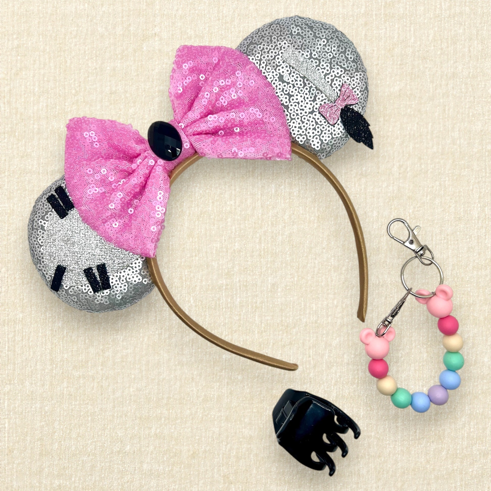 Gray sequin mouse ears headband with donkey-inspired silver glitter details and pink sequin bow; black claw clip; colorful rainbow beaded mouse ears holder
