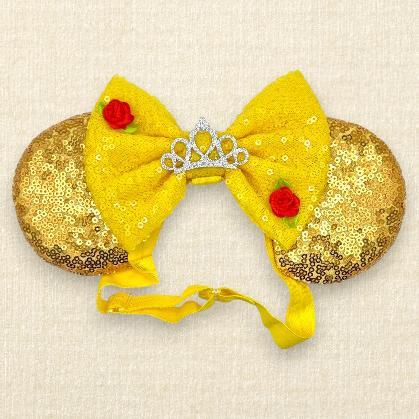 Gold sequin mouse ears with a yellow bow, silver tiara, and red roses on an elastic headband