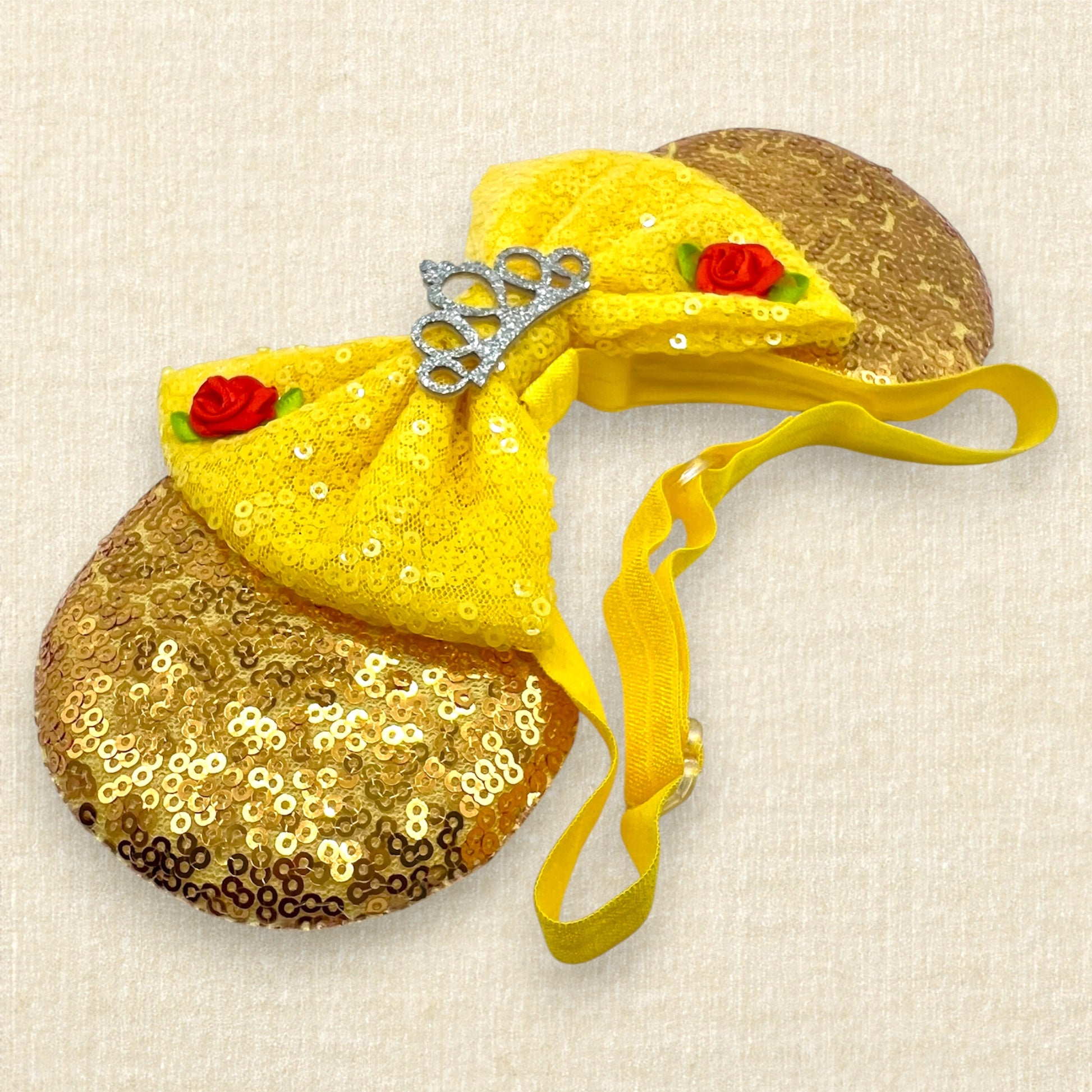 Gold sequin mouse ears with a yellow bow, silver tiara, and red roses on an elastic headband