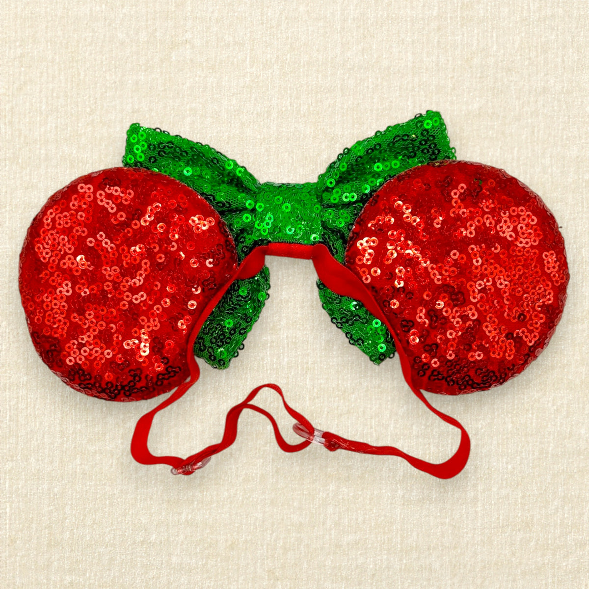A festive Christmas mouse ears headband with red sequin mouse ears, white snowflake details, and a green sequin bow on an elastic headband (back view)