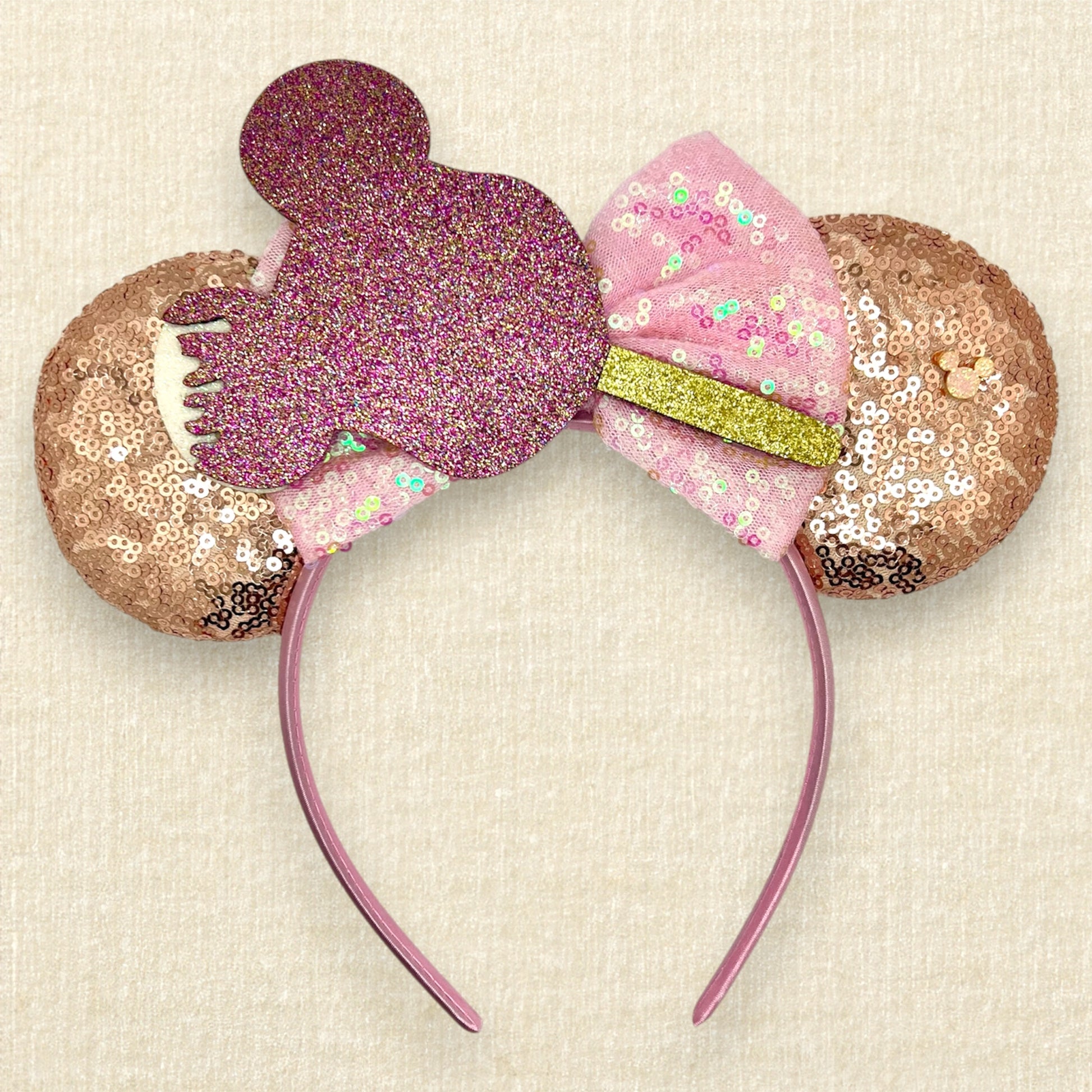 Rose gold sequin mouse ears with iridescent pink bow and glitter mouse-shaped ice cream bar