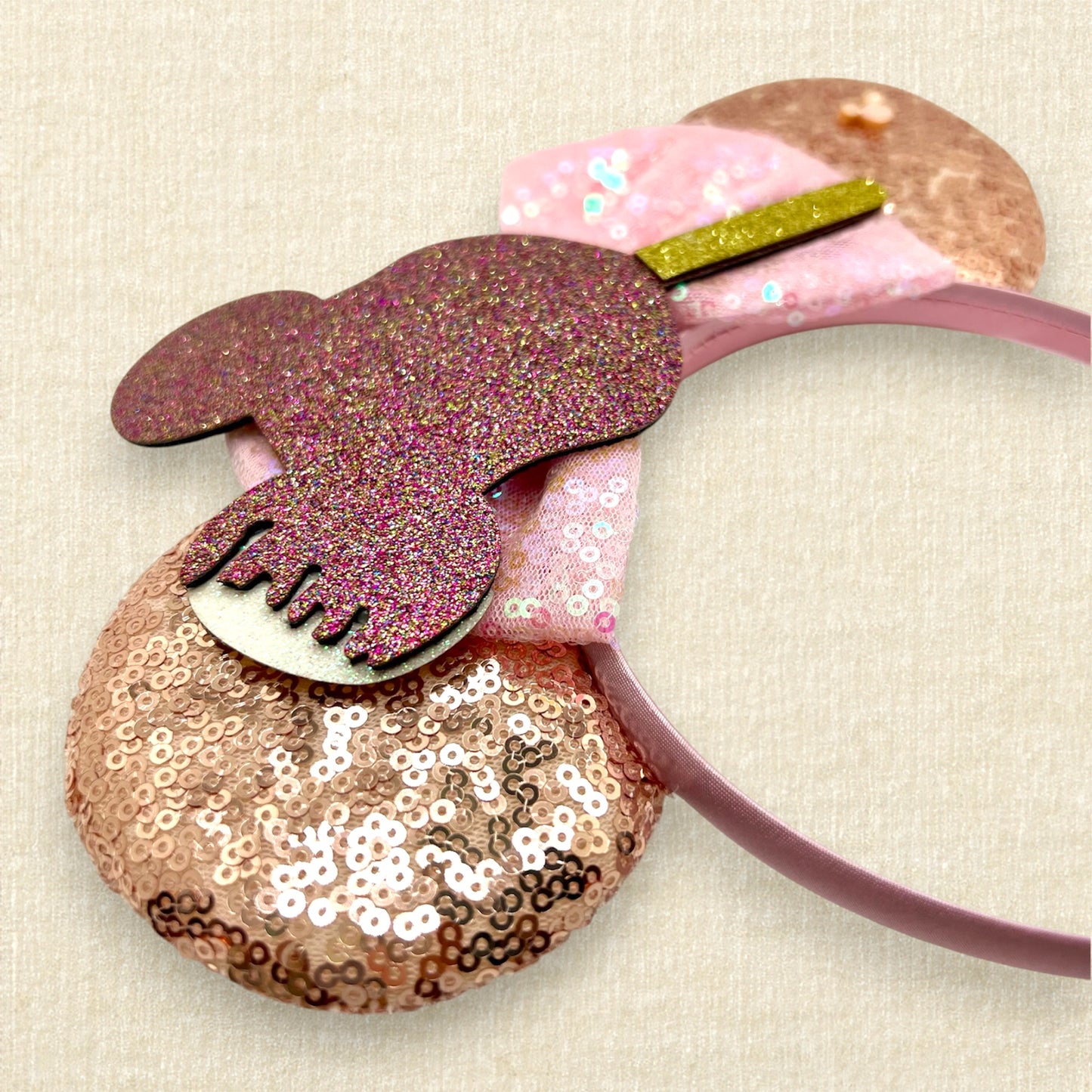 Rose gold sequin mouse ears with iridescent pink bow and glitter mouse-shaped ice cream bar