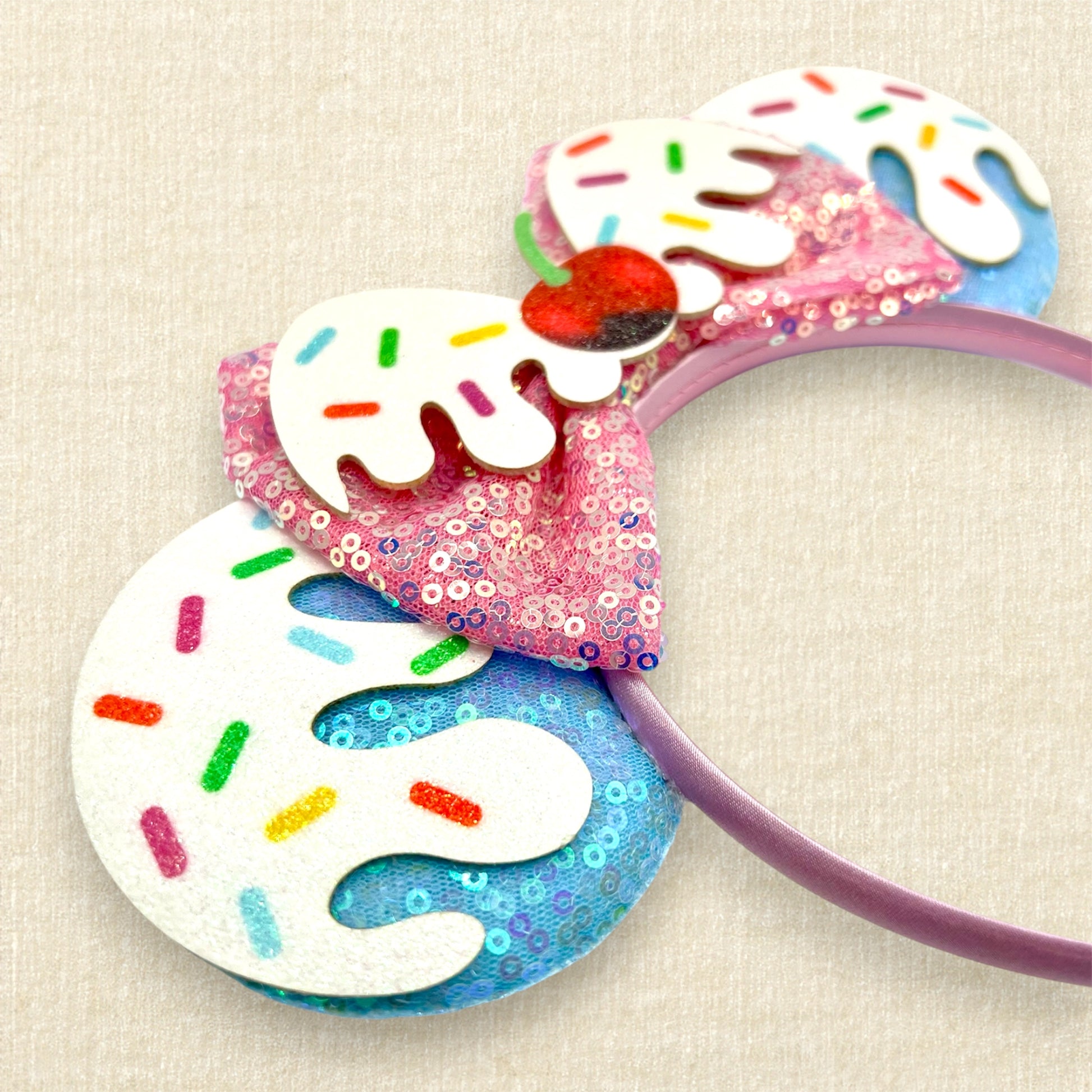 Colorful blue and pink ice cream-themed headband with sprinkles and cherry. 