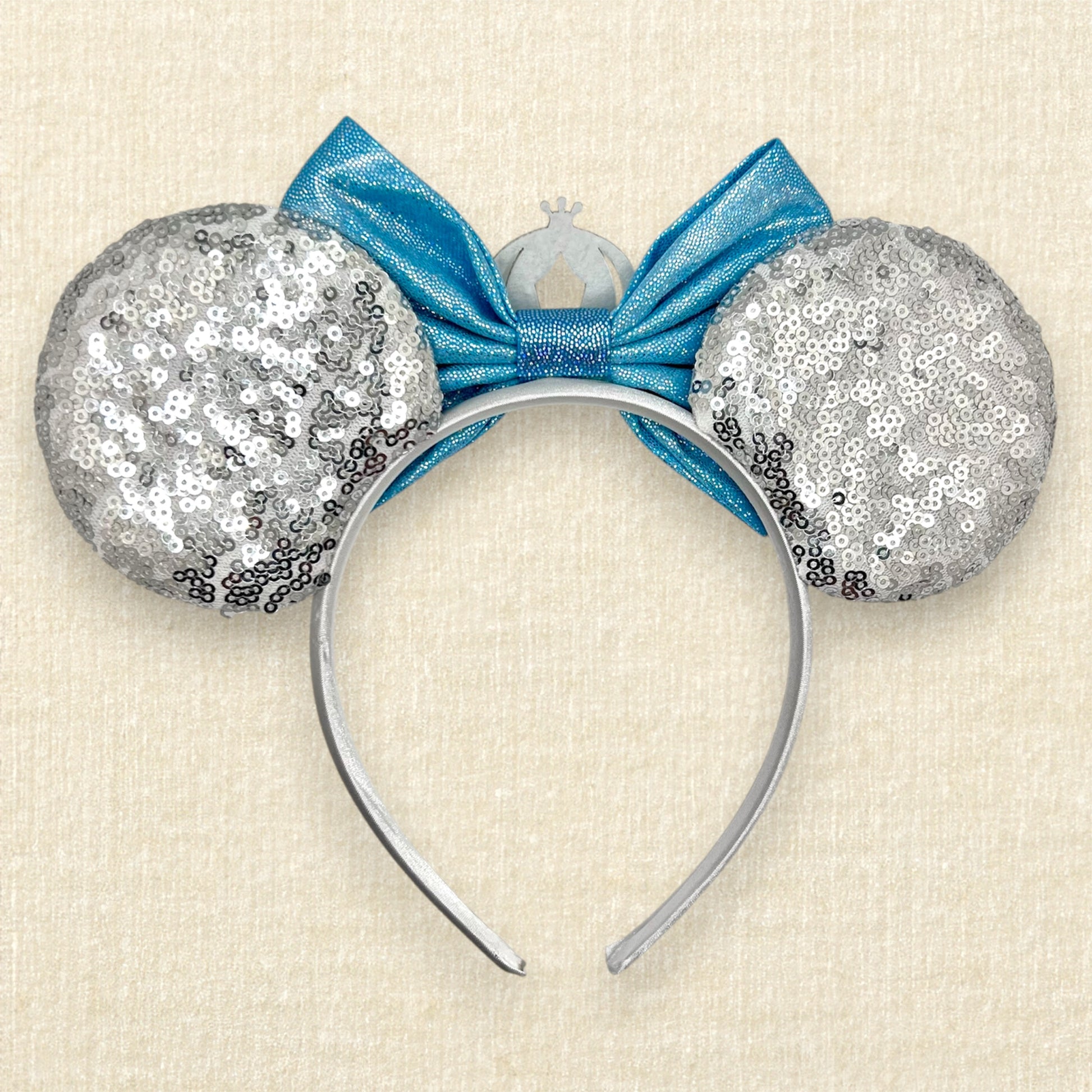 Silver sequin mouse ears with shimmery blue bow, silver glitter carriage accent, and rhinestones (back view)