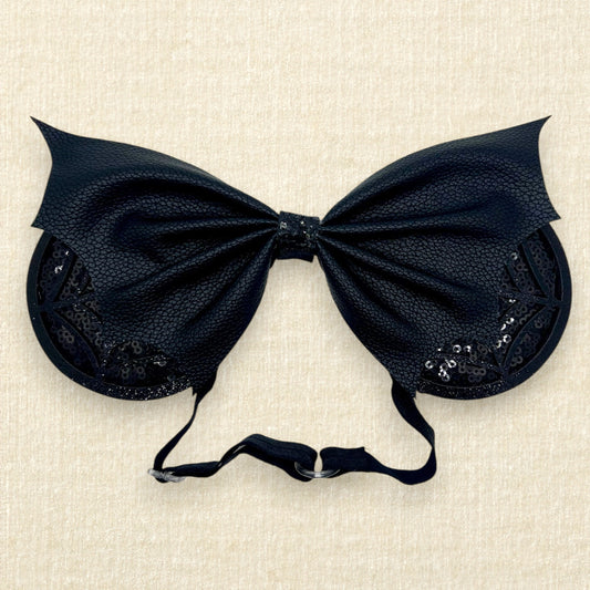 Halloween-themed mouse ears with black sequin ears, black glitter cobwebs, and black faux leather bat wing bow on an elastic headband