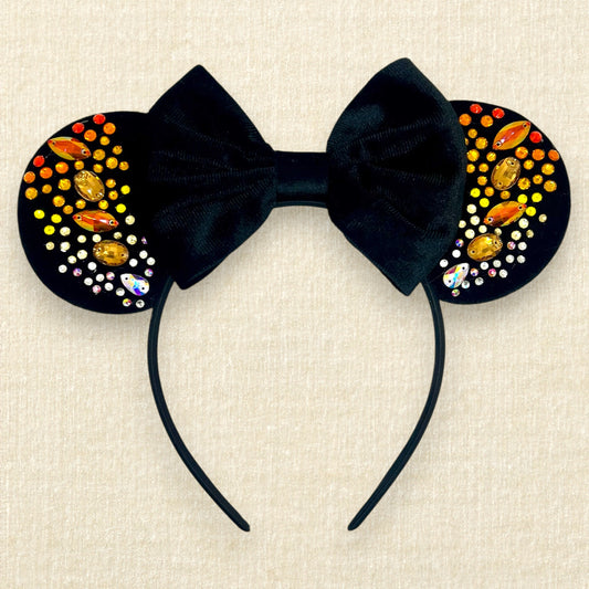 Black velvet mouse ears with black velvet bow and colorful rhinestones in a red, orange, yellow, and crystal ombre gradient pattern