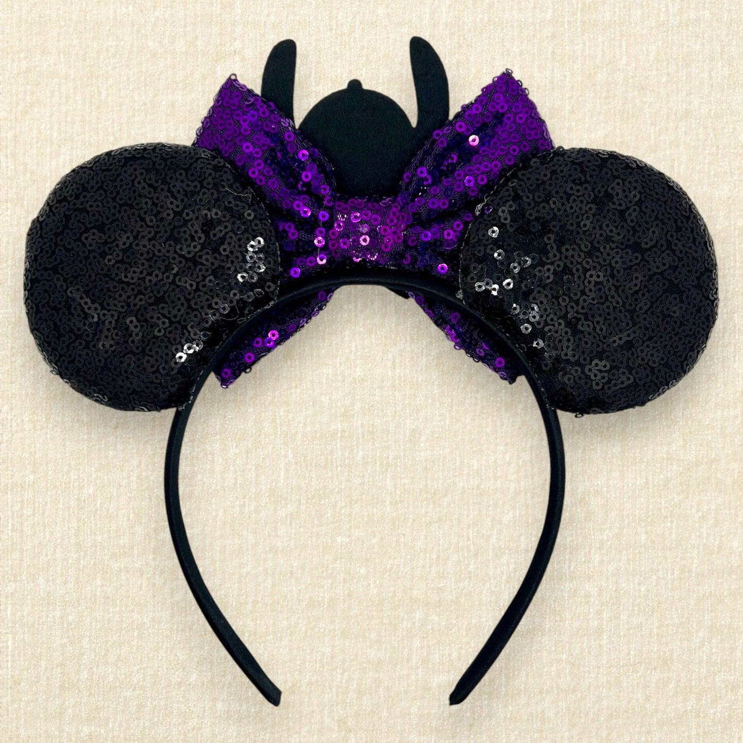 Halloween-themed black mouse ears headband with spooky glitter creatures, purple sequin bow, and skeleton Stitch centerpiece (back view)