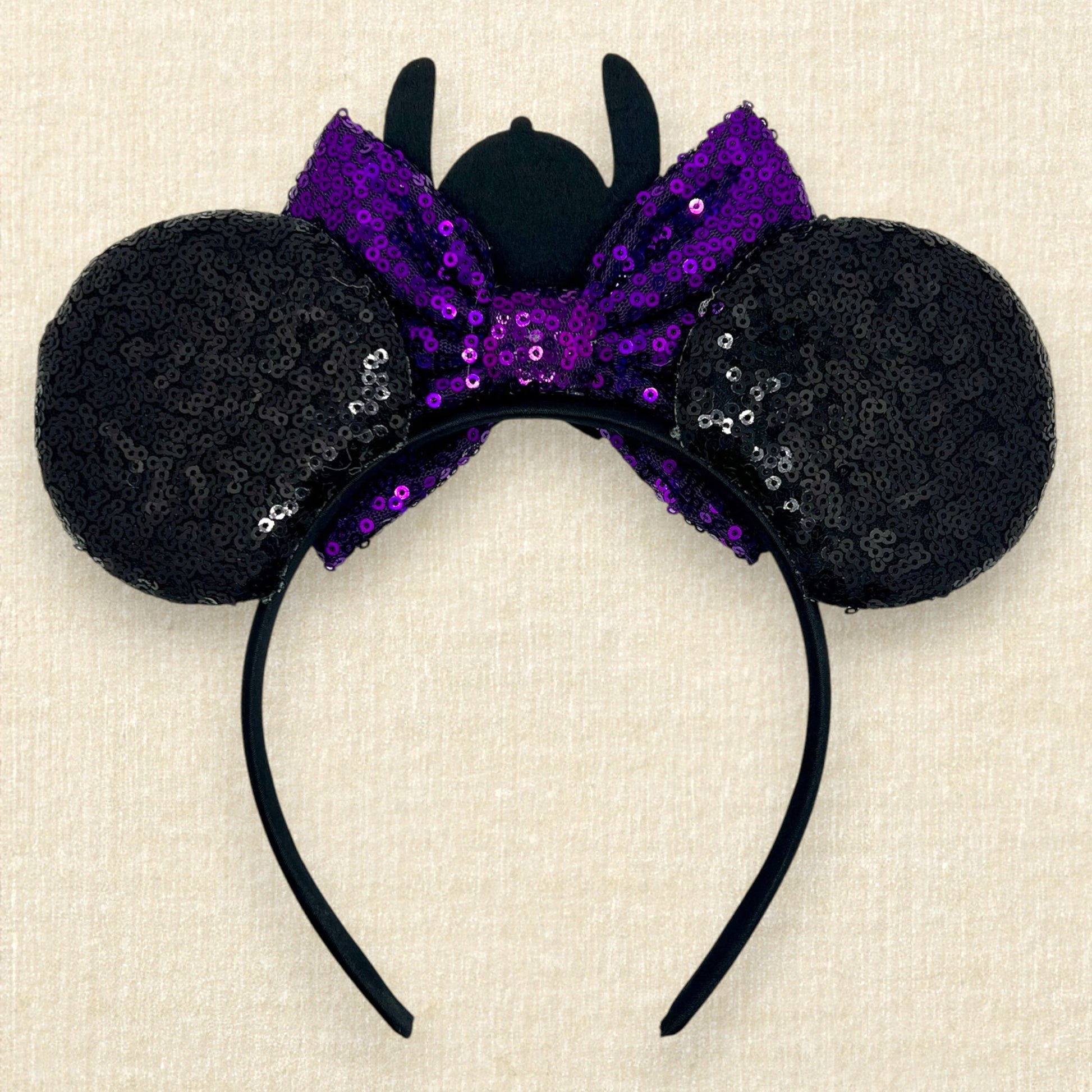Halloween-themed black mouse ears headband with spooky glitter creatures, purple sequin bow, and skeleton Stitch centerpiece (back view)