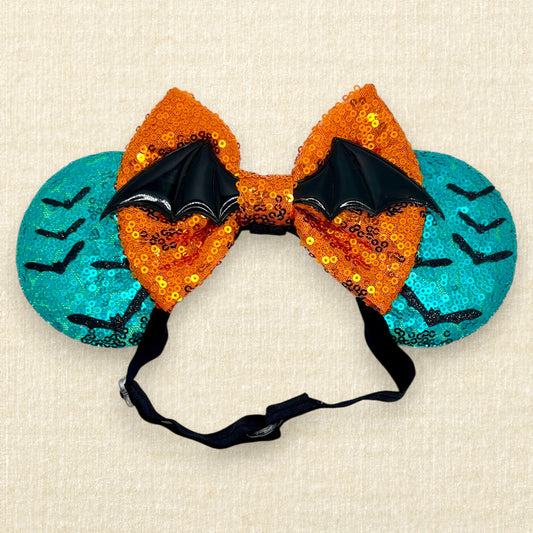 Halloween-themed teal mouse ears with black bats, orange bow, and large bat wings